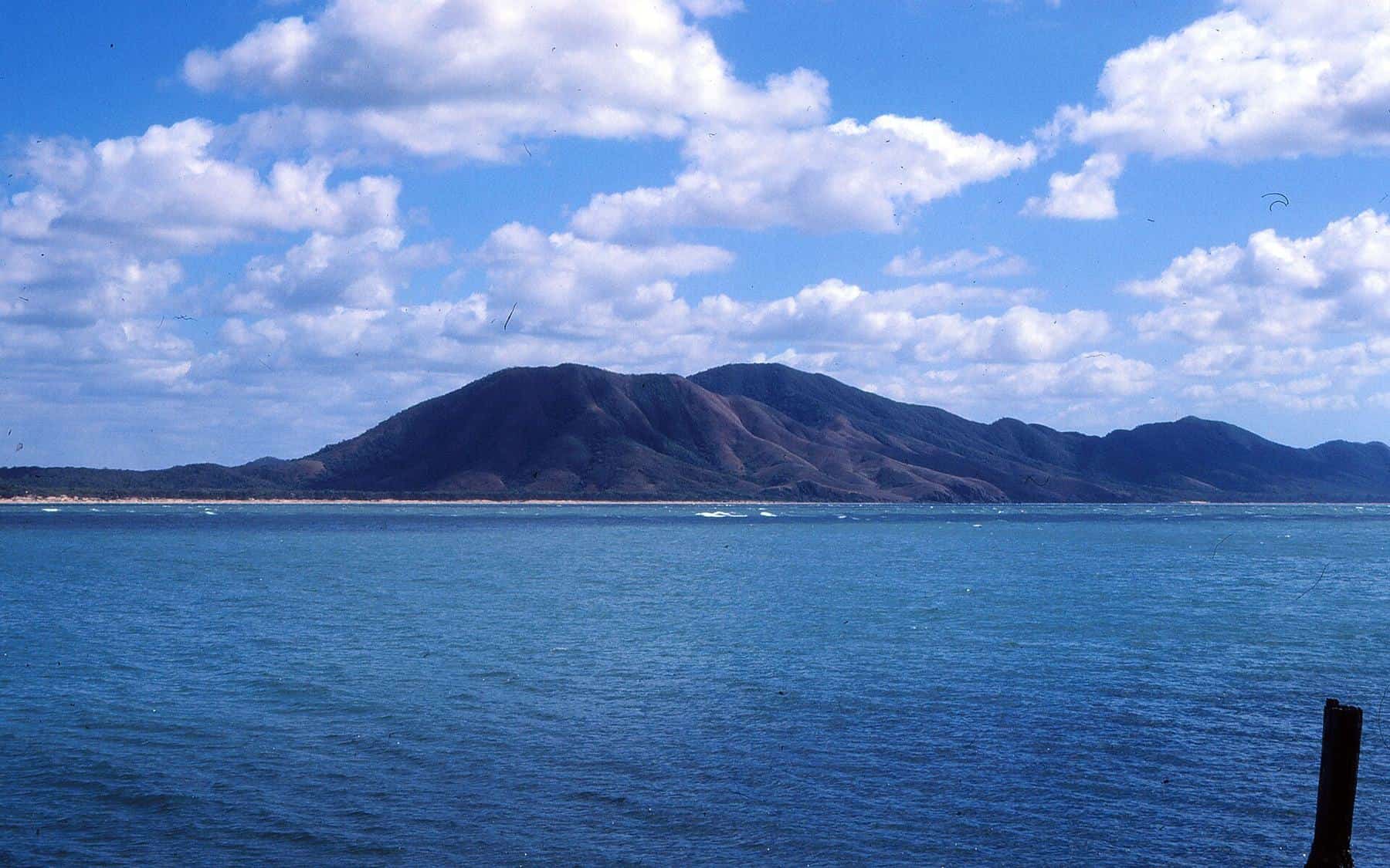 The wide mouth of the Endeavour River meeting the sea at Cooktown, with forested hills behind